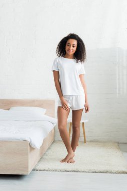 parlak odada duran, kameraya bakarak sevindim Afrikalı-Amerikalı kadın