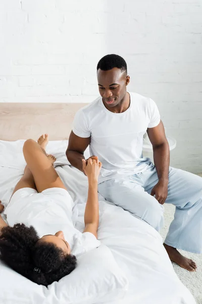 Afrikansk Amerikansk Man Sitter Sängen Tittar Vackra Flickvän — Stockfoto