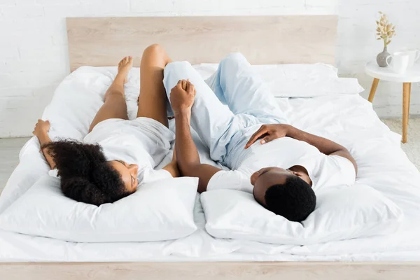 Overhead View African American Man Lying White Bed Holding Hands — Stock Photo, Image