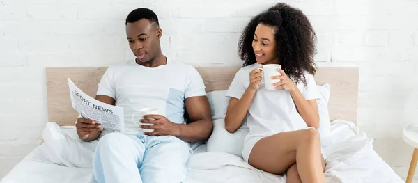 Pareja Afroamericana Pasando Mañana Cama Con Periódico Una Taza Bebida — Foto de Stock