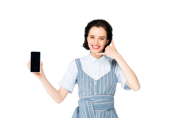 girl holding smartphone in hand, smiling and showing call me sign at camera isolated on white