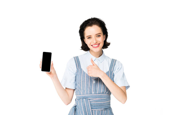 girl holding smartphone in hand, smiling and showing thumb up at camera isolated on white