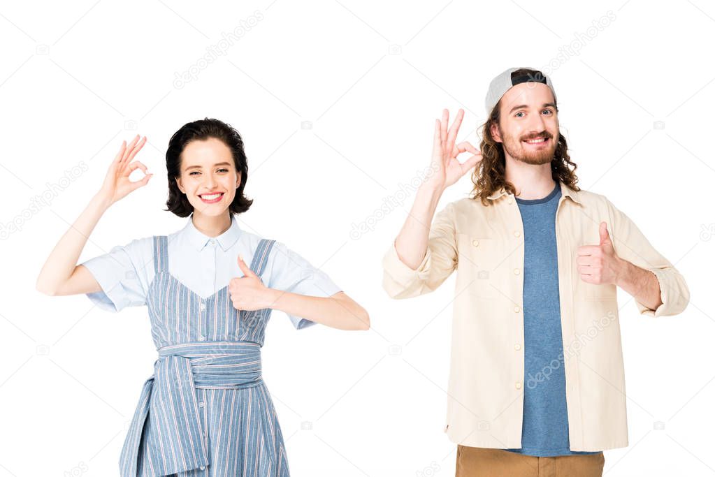 young man and girl showing thumbs up and Ok signs at camera isolated on white