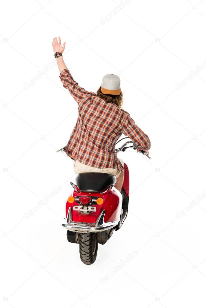 back view of young man with hand in air sittting on red scooter isolated on white