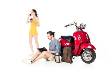samrtphone konuşan kız tam uzunlukta görünümü, kağıt bardak ve genç adam harita bakarak tutarak, beyaz izole kırmızı scooter yakınında oturan