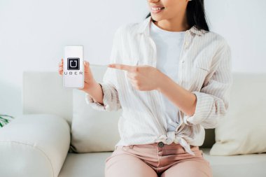 Kiev, Ukrayna - 26 Nisan 2019: Ekranda Uber uygulaması ile akıllı telefon parmak la işaret Latin kadının Kırpılmış çekim. 