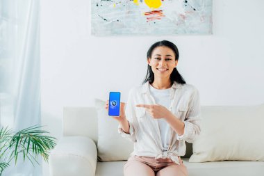 Kiev, Ukrayna - 26 Nisan 2019: Ekranda Shazam uygulaması ile akıllı telefon tutan güzel latin kadın. 