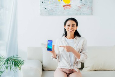 ekranda rezervasyon uygulaması ile akıllı telefon parmak ile işaret neşeli latin kadın