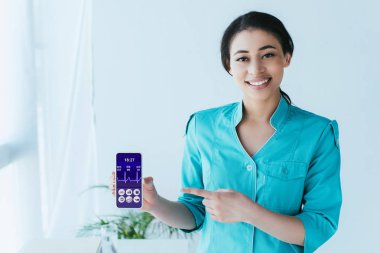 ekranda kalp atışı oranı ile akıllı telefon parmak ile işaret gülümseyen latin doktor