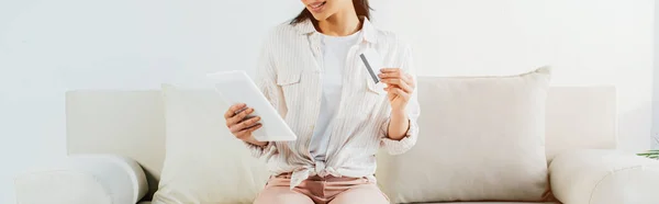 소파에 앉아있는 카드를 디지털 태블릿을 사용하는 여성의 — 스톡 사진