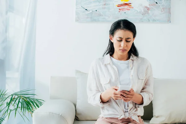Upset Latin Woman Using Smartphone While Sitting Couch Home — Stock Photo, Image