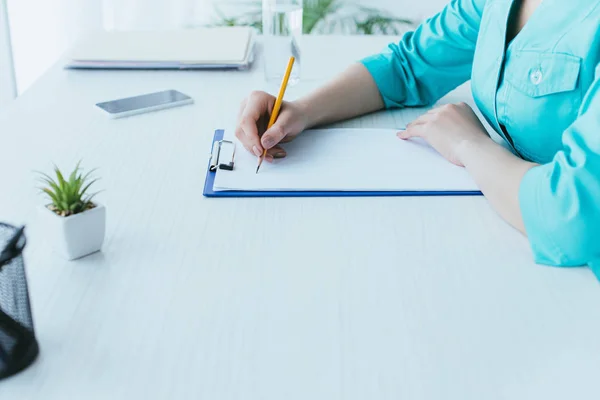 Cropped Shot Young Doctor Sitting Workplace Writing Clipboard — Stock Photo, Image