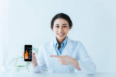 ekranda grafikler ve grafikler ile akıllı telefon parmak ile işaret gülümseyen latin doktor