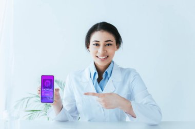 ekranda online alışveriş uygulaması ile akıllı telefon gösteren güzel latin doktor