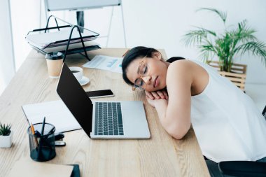boş ekran ile dizüstü yakın işyerinde uyuyan yorgun latin iş kadını