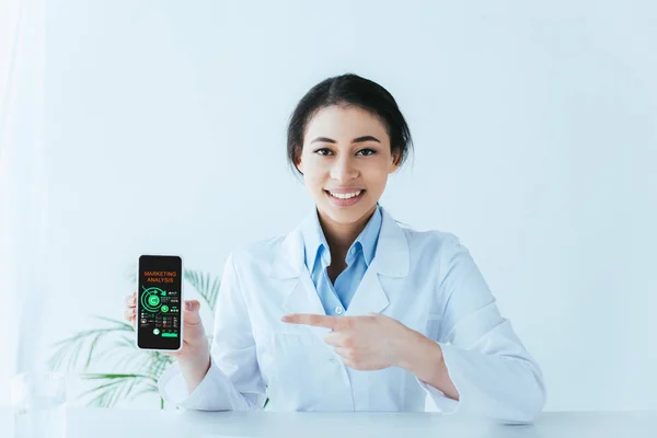 Young Latin Doctor Pointing Finger Smartphone Marketing Analysis Screen — Stock Photo, Image