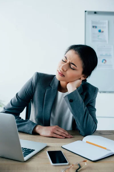 Tired Latin Businesswoman Holding Hand Neck While Sitting Workplace Closed — Stock Photo, Image