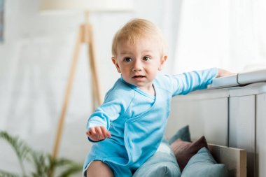 modern yatak odasında sevimli yürümeye başlayan çocuğun seçici odak 