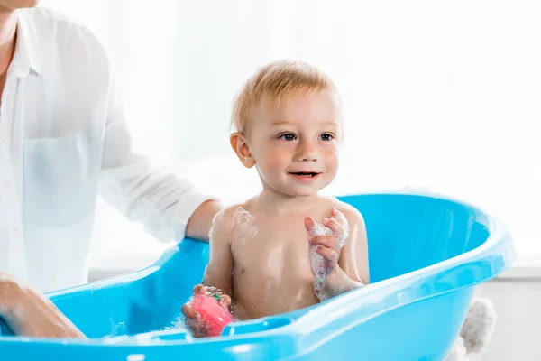 Cropped View Mother Washing Happy Toddler Son Blue Baby Bathtub — Stock Photo, Image