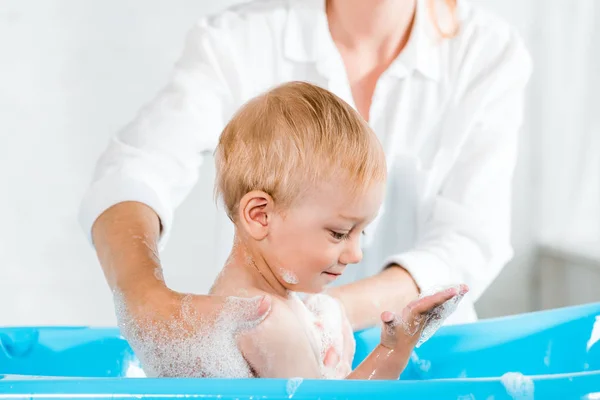 Vista Recortada Mujer Lavando Lindo Niño Pequeño Mirando Espuma Baño —  Fotos de Stock
