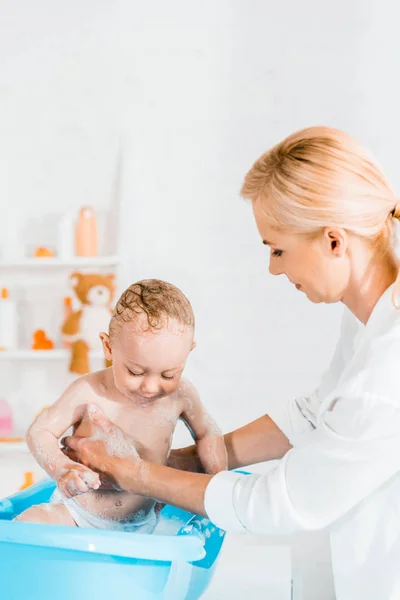 Atraktivní Blondýnka Promývací Roztomilý Batole Syn Koupelně — Stock fotografie