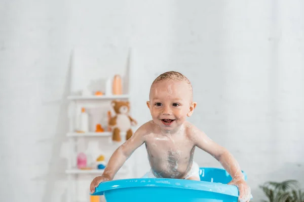 Малюк Приймає Ванну Посміхається Синій Пластиковій Дитячій Ванні Вдома — стокове фото