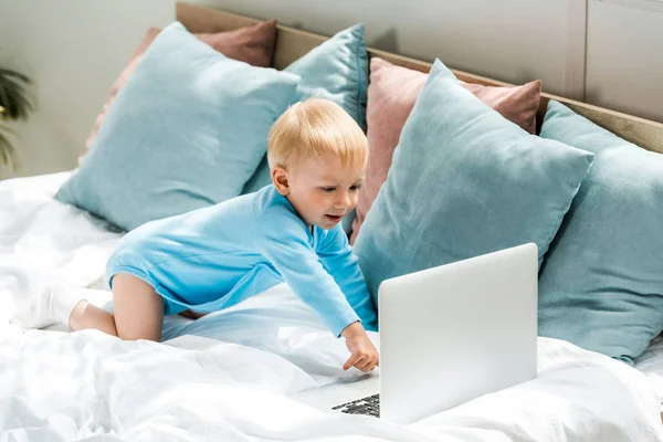 Niño Pequeño Feliz Gesto Cerca Computadora Portátil Cerca Almohadas Cama — Foto de Stock