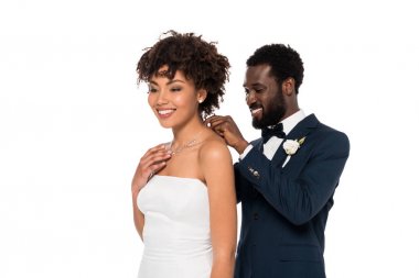mutlu Afrikalı Amerikan damat beyaz üzerinde izole çekici gelin kolye giyiyor 