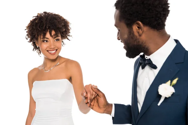 白に隔離された手を保持しながら花婿を見て陽気なアフリカ系アメリカ人の花嫁の選択的な焦点 — ストック写真