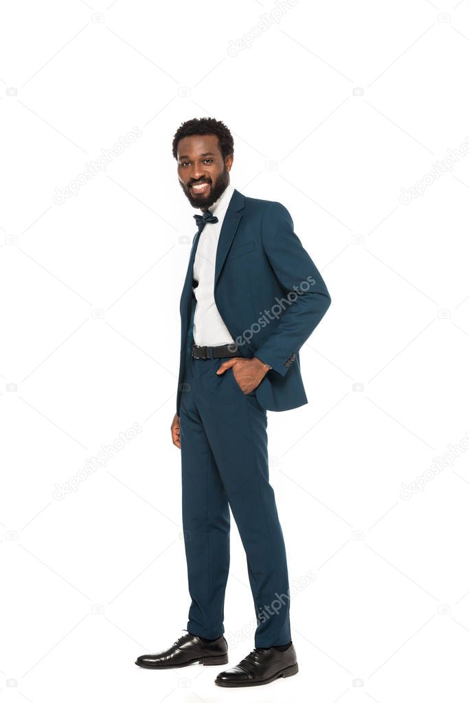 happy african american bridegroom standing with hand in pocket isolated on white 