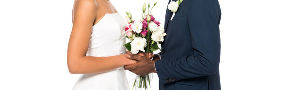 panoramic shot of african american bride and bridegroom holding bouquet isolated on white