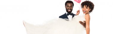 beyaz üzerinde izole gelinlik silah gelin tutan yakışıklı Afrikalı Amerikan damat panoramik çekim 
