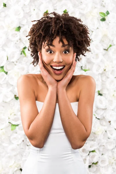 Emocionado Afroamericano Novia Tocando Cara Mientras Mira Cámara Cerca Flores — Foto de Stock