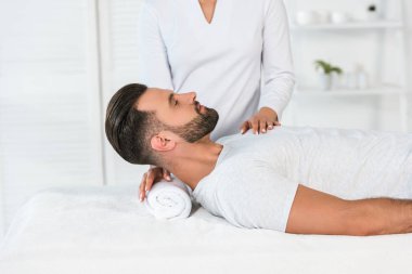 spa merkezinde yakışıklı adam yakınında duran şifacı kırpılmış görünümü 
