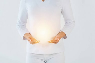 cropped view of healer standing and gesturing near light isolated on white  clipart