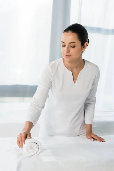 Atraente Morena Massagista Perto Mesa Massagem Olhando Para Rolo Toalha — Fotografia de Stock