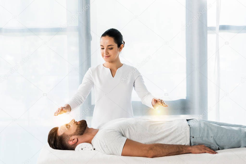 attractive woman putting hands above body while healing handsome bearded man 