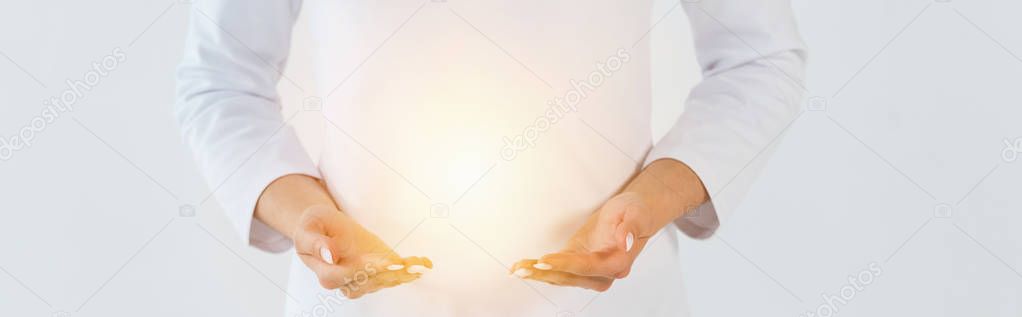 panoramic shot of healer standing and gesturing near light isolated on white 