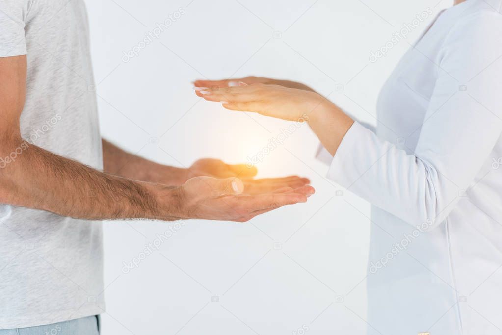 cropped view of woman healing hands of man isolated on white 