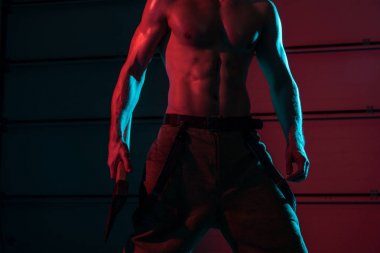 partial view of sexy shirtless fireman holding flat head axe in darkness clipart