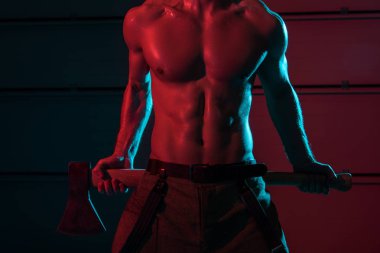 partial view of sexy shirtless fireman holding flat head axe in darkness clipart