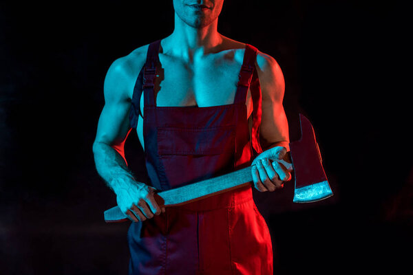 обрезанный вид пожарного без рубашки с плоским топором на черном
