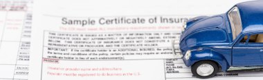 panoramic shot of blue toy car on insurance documents clipart