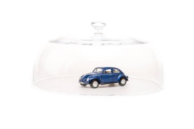 beyaz izole cam cloche altında mavi oyuncak araba