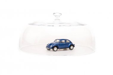 blue toy car under glass cloche isolated on white clipart