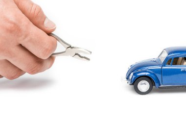 cropped view of man holding pliers and blue toy car on white clipart