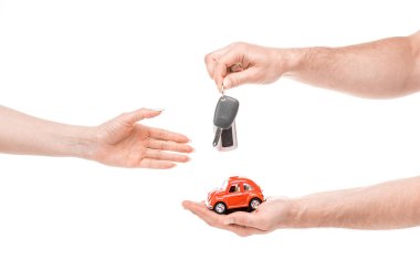cropped view of man giving toy car and keys to woman isolated on white clipart