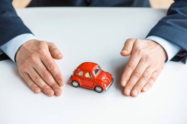 kırmızı oyuncak araba ile resmi giyim adam kırpılmış görünümü