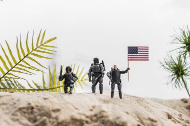 kum kumul üzerinde Amerikan bayrağı tutan oyuncak askerlerin seçici odak