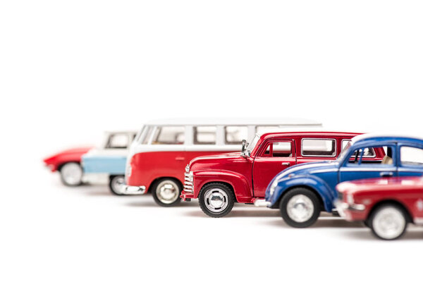 selective focus of colorful toy cars and bus on white